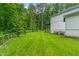 A long backyard with fresh cut lawn featuring a white home, dark pergola, and a wood fence at 322 Scheer Ave, Durham, NC 27703