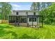 A well-maintained backyard featuring a white house with a dark pergola and screened porch at 322 Scheer Ave, Durham, NC 27703