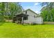 Expansive backyard showing the side of this white home with a dark pergola and screened in porch at 322 Scheer Ave, Durham, NC 27703