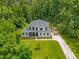 Exterior view of a modern farmhouse with mature trees and a well manicured lawn at 322 Scheer Ave, Durham, NC 27703