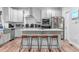Bright kitchen boasts white cabinets, stainless steel appliances, and a large island with seating at 322 Scheer Ave, Durham, NC 27703