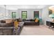 Comfortable living area with an expansive couch, large windows, and a modern entertainment setup at 322 Scheer Ave, Durham, NC 27703