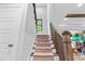 Staircase with carpeted steps and wood railing, leading up to the next floor with natural light at 322 Scheer Ave, Durham, NC 27703
