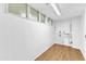 Unfinished basement area with white walls, wood-look flooring, and small windows at 3221 Ward Rd, Raleigh, NC 27604