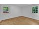 Sunlit bedroom featuring hardwood floors and two windows for ample light at 3221 Ward Rd, Raleigh, NC 27604
