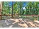 A wood deck overlooks a large backyard with mature trees, featuring brown railings and steps down to the lawn at 3221 Ward Rd, Raleigh, NC 27604
