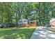 Two-story home boasts brick and siding details, a long driveway, and is surrounded by a lush, green lawn with mature trees at 3221 Ward Rd, Raleigh, NC 27604