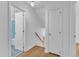Hallway with hardwood floors leads to the bathroom and staircase at 3221 Ward Rd, Raleigh, NC 27604
