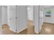 Bright hallway with hardwood floors and white walls provides a view to the adjacent rooms with natural light at 3221 Ward Rd, Raleigh, NC 27604