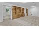 Spacious living area with built-in wooden cabinets and neutral carpeting, connecting to the next room at 3221 Ward Rd, Raleigh, NC 27604