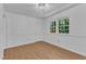 Bright room with hardwood floors, white walls, trim, and natural light coming from two windows at 3221 Ward Rd, Raleigh, NC 27604