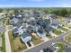 Expansive aerial view of a neighborhood with diverse architectural styles, garages, and green spaces at 34 Millennium Dr, Pittsboro, NC 27312