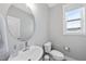 Bathroom with a modern rounded mirror, vessel sink, and view out window at 34 Millennium Dr, Pittsboro, NC 27312