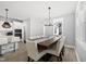 Elegant dining room with a large table, stylish chandelier, and views of the outdoors at 34 Millennium Dr, Pittsboro, NC 27312