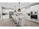 Open kitchen area with a center island with seating, stainless steel appliances, and light wood flooring at 34 Millennium Dr, Pittsboro, NC 27312