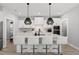 Bright kitchen featuring a large island with seating and modern black pendant lighting and stainless appliances at 34 Millennium Dr, Pittsboro, NC 27312