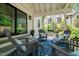 Covered back patio with outdoor furniture, blue rug, and backyard views overlooking fire pit area at 3540 Rugby Rd, Durham, NC 27707
