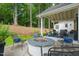 Backyard patio with a brick fire pit, surrounded by chairs, and mature trees in the background at 3540 Rugby Rd, Durham, NC 27707
