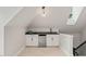 Finished attic space with custom wet bar that includes beverage fridge, sink, and grey countertop at 3540 Rugby Rd, Durham, NC 27707