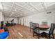 Finished basement with drop ceiling, wood-look floors, exercise equipment and table with seating at 3540 Rugby Rd, Durham, NC 27707