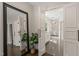 Bathroom with a framed mirror, double doors and tiled floors and a view into the glass enclosed shower at 3540 Rugby Rd, Durham, NC 27707