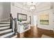 Elegant foyer featuring hardwood floors, decorative mirror, and staircase with wrought iron spindles at 3540 Rugby Rd, Durham, NC 27707