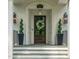Elegant front entrance with dark wood door, classic sconces, and spiral topiaries at 3540 Rugby Rd, Durham, NC 27707