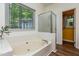Bathroom with soaking tub and glass enclosed shower, with large window providing natural light at 3616 Culater Ct, Raleigh, NC 27616