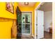 Bright yellow entryway featuring a black front door with porch view, wood floors, and white trim at 3616 Culater Ct, Raleigh, NC 27616