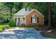 Charming brick home with a gabled roof, black shutters, and a welcoming front porch surrounded by lush greenery at 3616 Culater Ct, Raleigh, NC 27616
