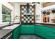 Bright kitchen features emerald cabinets, black countertops, and stylish tile backsplash at 3616 Culater Ct, Raleigh, NC 27616