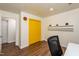 Bright office space featuring yellow closet doors, floating shelves, and hardwood flooring at 3616 Culater Ct, Raleigh, NC 27616