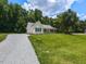 Quaint home with a spacious yard and a long driveway nestled among mature trees at 381 Gray Ghost Ln, Benson, NC 27504
