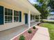 Inviting front porch with white columns and blue door framed by manicured landscaping at 381 Gray Ghost Ln, Benson, NC 27504