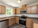 Kitchen features stainless steel appliances and light wood cabinetry with dark countertops at 381 Gray Ghost Ln, Benson, NC 27504