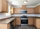 Well-lit kitchen with wood cabinets, stainless steel appliances and a cozy window at 381 Gray Ghost Ln, Benson, NC 27504