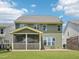 Expansive backyard view of the two-story home featuring a covered patio and green lawn at 3901 Yates Mill Trl, Raleigh, NC 27606