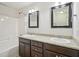 Bathroom with dual sinks, granite countertops, dark wood cabinets, and shower-tub combo at 3901 Yates Mill Trl, Raleigh, NC 27606