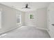 Bright bedroom with neutral walls, ceiling fan, and windows showcasing outdoor views at 3901 Yates Mill Trl, Raleigh, NC 27606