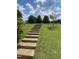 Wooden staircase leading up a grassy knoll in a serene setting at 3901 Yates Mill Trl, Raleigh, NC 27606