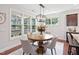 Bright dining area with hardwood floors, stylish chandelier, large windows, and views of the backyard at 3901 Yates Mill Trl, Raleigh, NC 27606