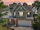Stunning exterior view of a two-story home with stone accents and a two-car garage at sunset at 3901 Yates Mill Trl, Raleigh, NC 27606