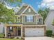 Two-story home with green siding, stone accents, and a two-car garage on a sunny day at 3901 Yates Mill Trl, Raleigh, NC 27606