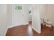 Bright foyer featuring hardwood floors, a white door, and a glimpse into the half bathroom at 3901 Yates Mill Trl, Raleigh, NC 27606