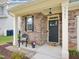 Inviting front porch with stone accents, a chair, and a 'hello' doormat at 3901 Yates Mill Trl, Raleigh, NC 27606