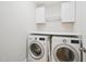 Bright laundry room featuring modern washer and dryer with white cabinets and countertop space at 3901 Yates Mill Trl, Raleigh, NC 27606