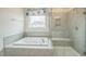 Bright bathroom features a soaking tub with tile surround and a separate glass shower with a built-in seat at 40 Two Creeks Loop, Chapel Hill, NC 27517