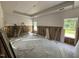 Bedroom under construction featuring a tray ceiling, insulation, drywall work, and natural light from two windows at 4024 N Nc 581 Hwy, Kenly, NC 27542