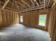 Framed bedroom with exposed wood and under-construction features, illuminated by natural light from a window at 4024 N Nc 581 Hwy, Kenly, NC 27542
