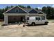 New construction home featuring a gray facade, open garage, and a work van in the driveway at 4024 N Nc 581 Hwy, Kenly, NC 27542